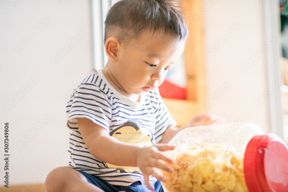 Adorable toddler baby boy with snack food in home Adorable toddler baby boy with snack food in home