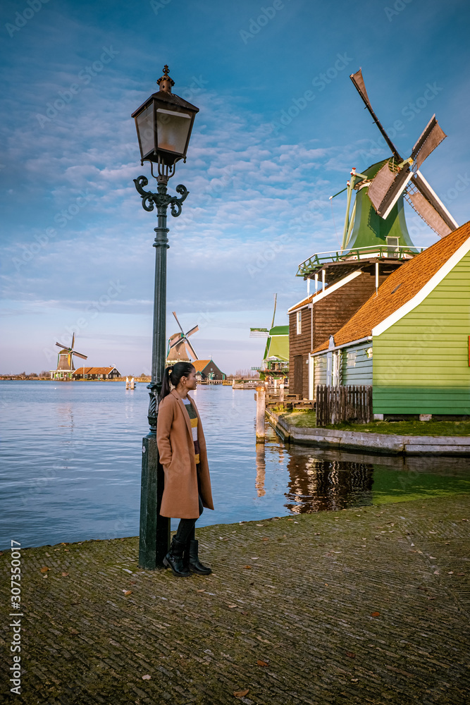 Photo & Art Print woman walking at the old windmill village Zaanse 