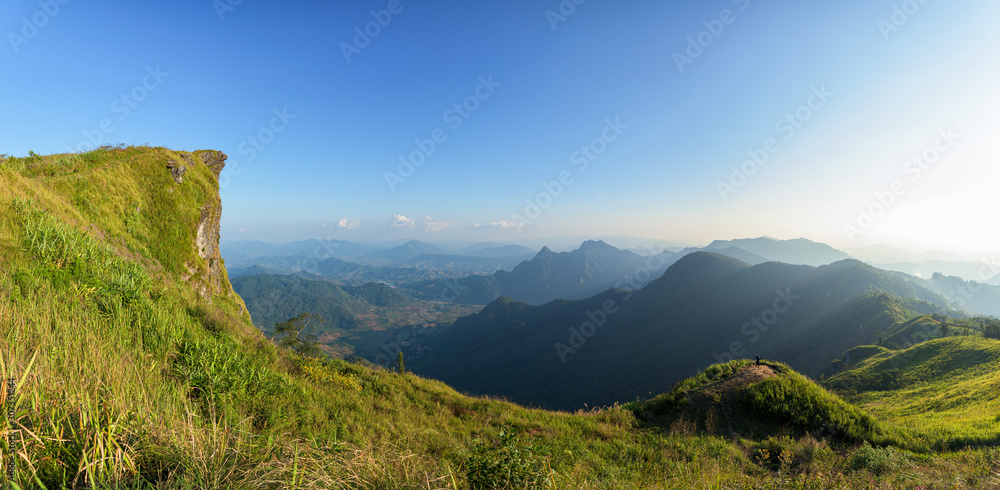 Man traveler on cliff with beautiful landscape sunset at Phu Chi Fa and national forest park in Thailand.