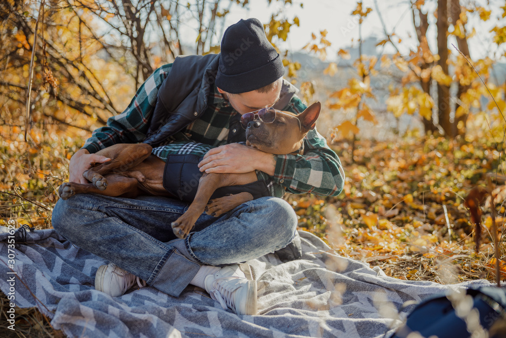 Fototapeta premium Man kissing the dog and putting glasses on him stock photo