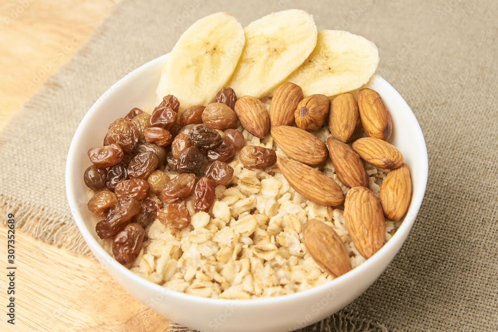 Oatmeal breakfast bowl. Organic healthy food with candied fruit raisins, nuts, banana Oatmeal breakfast bowl. Organic healthy food with candied fruit raisins, nuts, banana