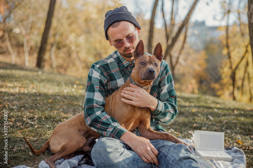 Owner in glasses sitting with his pet stock photo