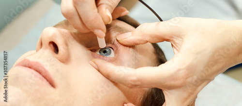 ophthalmologist doctor in exam optician laboratory with male patient. Men eye care medical diagnostic. Eyelid treatment