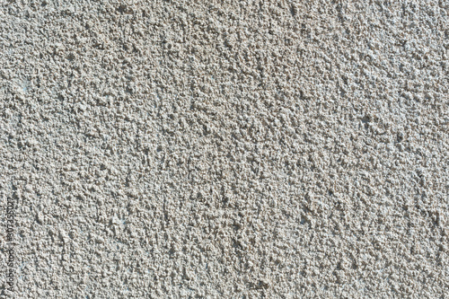 Coarse-grained textured gray background cement finish of the building facade with cement putty