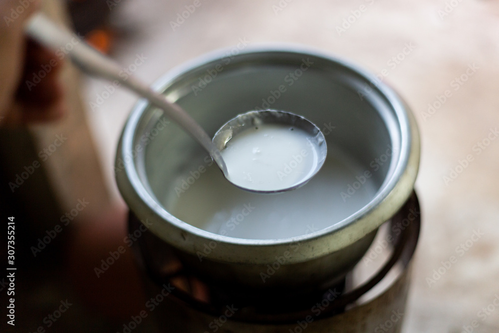 Filling coconut milk into Thai food wrapped in banana leaves 