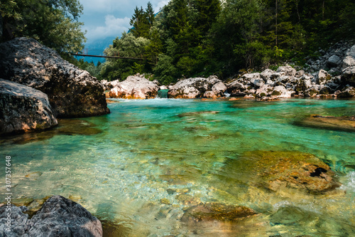 Fototapeta Naklejka Na Ścianę i Meble -  Soča river in Slovenia, ideal place for relax and swimming and bath, freezing cold water, beatiful green water inbetween rocks, with bridge to cross