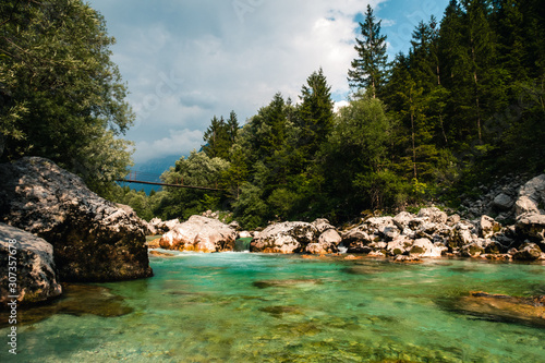 Soča river in Slovenia, ideal place for relax and swimming and bath, freezing cold water, beatiful green water inbetween rocks, with bridge to cross