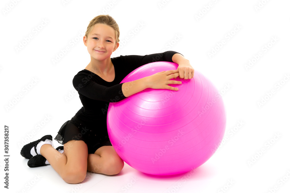little girl doing exercises on a big ball for fitness. little girl doing exercises on a big ball for fitness.