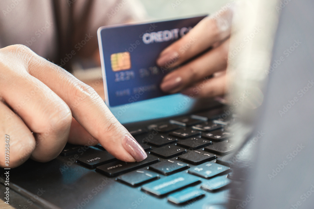 hand holding credit card and using computer for online shopping hand holding credit card and using computer for online shopping