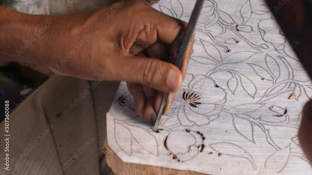 Man carving a beautiful floral design for a wooden block printing  .