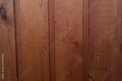 Background from boards of red color. Thick wallpaper from oak planks. Abstract old decorative element.