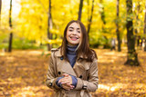 Portrait of an autumn woman with yellow leaves and smiling