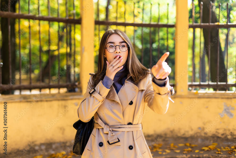 Fototapeta premium Young beautiful female dreaming in the autumn park.
