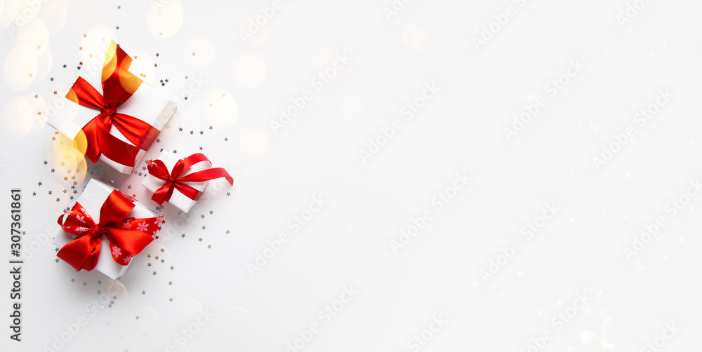 Christmas and New Year holiday background. Xmas greeting card. Christmas red ribbon gifts and ornaments on white background top view - obrazy, fototapety, plakaty 