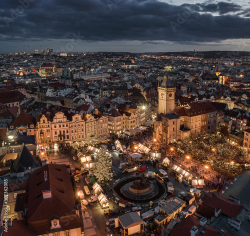 Prague, Czech Republic - Aerial panoramic drone view of the famous Christmas market of city Prague at the Old Town Square with illuminated Old Town Hall at background at winter time