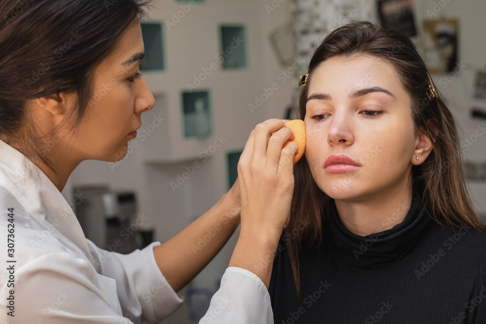 Make-up artist work, applying model makeup in the studio, close-up Make-up artist work, applying model makeup in the studio, close-up