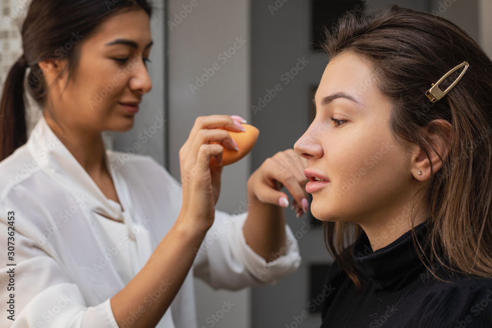 Make-up artist work, applying model makeup in the studio, close-up