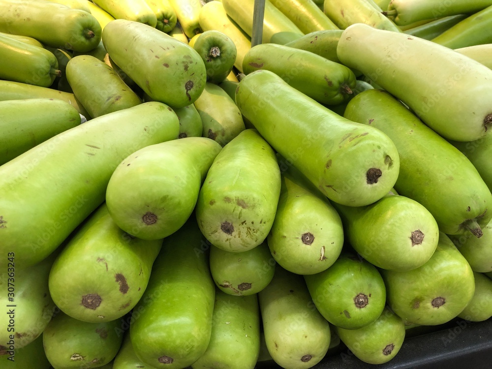 Close up shot of long green gourds at a fresh market section