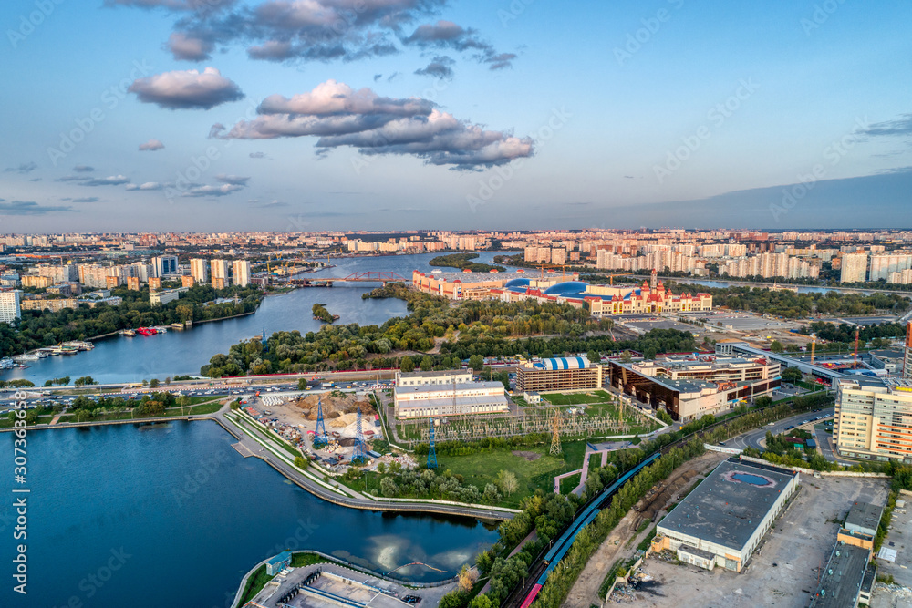 Fototapeta premium Big city aerial shot. Long and wide streets filled with cars. Shooting in the evening with the setting sun.