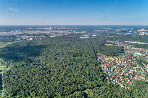 Large green forest. A multi-lane highway runs through the forest. Aerial view, summer sunny day. © nordroden