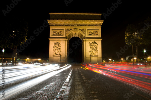 Paris triumphal arch illuminated at night, Étoile Arch, with car light trails