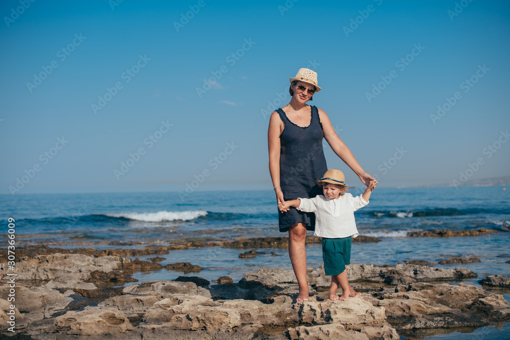 Mom with a little son on a trip near the sea.