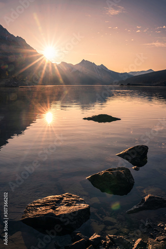 Sunrise on rocky mountain with rocks in Medicine lake at Jasper national park