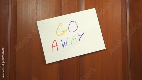 Door with a hand written GO AWAY sign closing. Trying to get away from it all to find privacy and solitude.