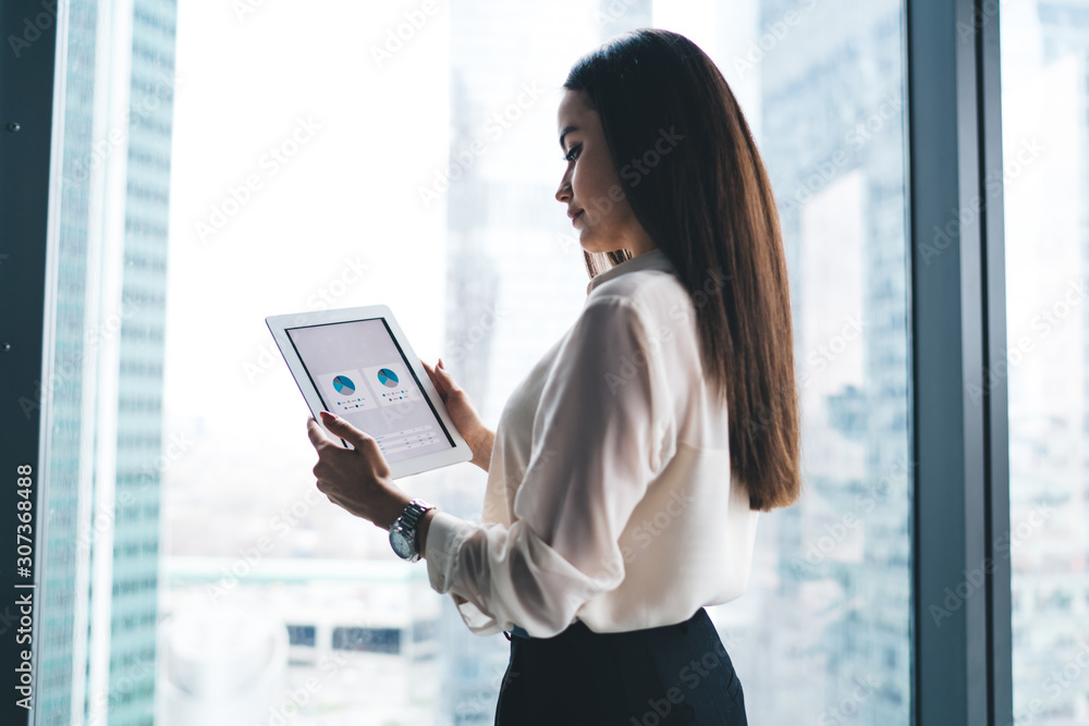Young manager using tablet near window Young manager using tablet near window