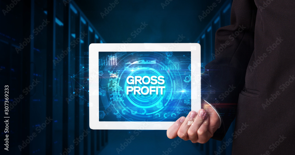 Young business person working on tablet and shows the inscription: GROSS PROFIT, business concept Young business person working on tablet and shows the inscription: GROSS PROFIT, business concept
