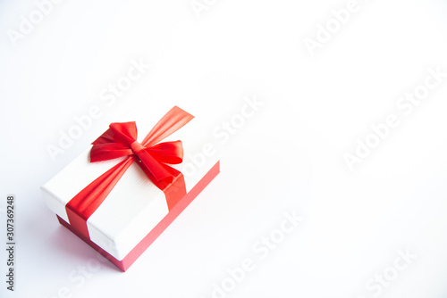 Fototapeta Naklejka Na Ścianę i Meble -  Beautiful Christmas gift box with red ribbon on isolated background. Happy New Year and merry christmas.