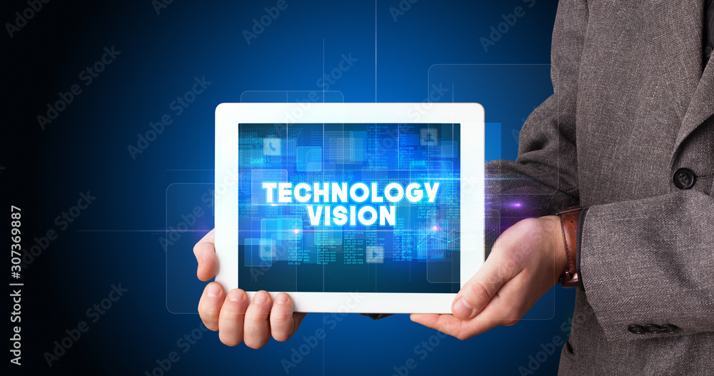 Young business person working on tablet and shows the inscription: TECHNOLOGY VISION Young business person working on tablet and shows the inscription: TECHNOLOGY VISION