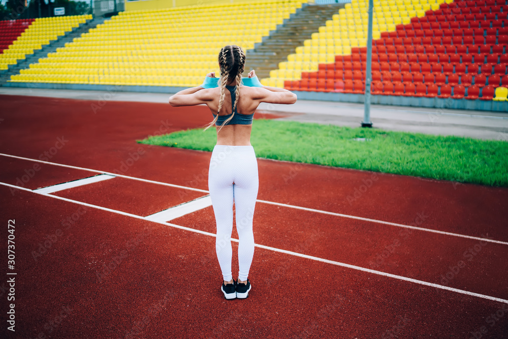 Strong female athlete training on stadium