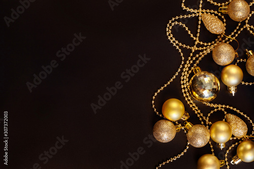 Golden christmas decorations on black background with copy space.