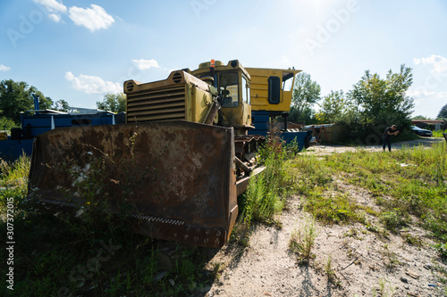 Wallpaper Mural Old yellow rusty tractor in field in sunny day. Torontodigital.ca
