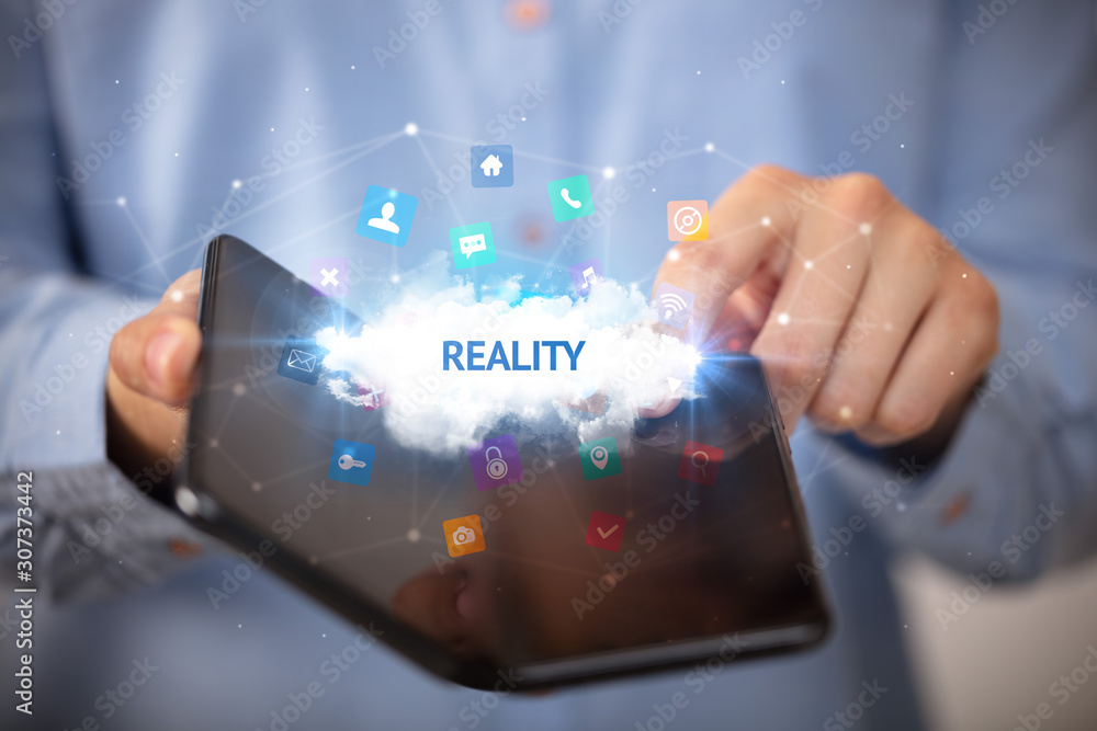 Businessman holding a foldable smartphone with REALITY inscription, technology concept Businessman holding a foldable smartphone with REALITY inscription, technology concept