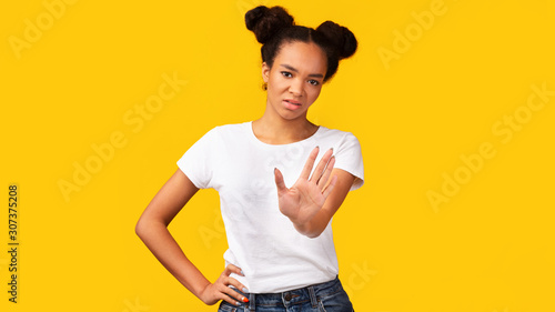Cuadro en lienzo Young black woman showing stop sign over yellow background