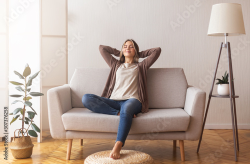 Millennial girl relaxing at home on couch, enjoying free time #307376258
