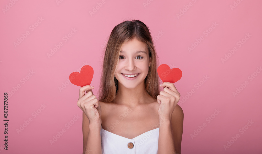 Close-up of a young girl with paper red hearts. Close-up of a young girl with paper red hearts.