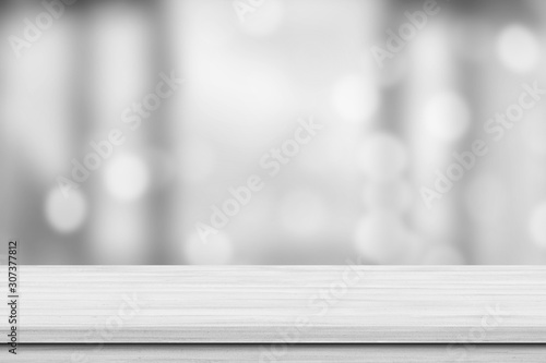 White wood tabletop over blur white bokeh light background. Empty wood shelf for product display, banner or mockup. photo