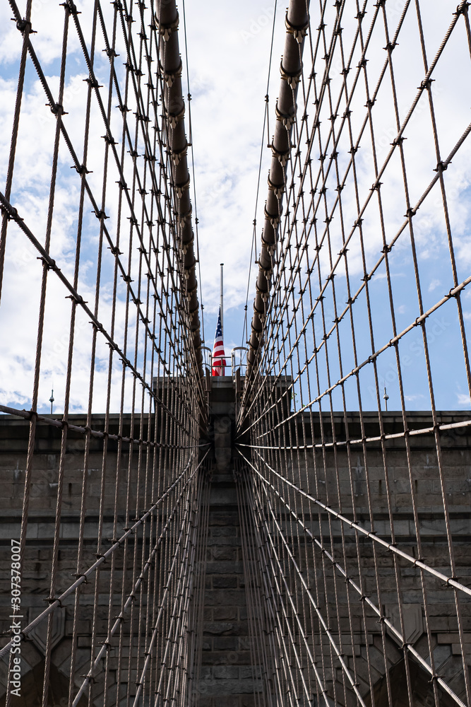 Obraz premium Vista de la bandera americana situada en la parte superior del Puente de Brooklyn