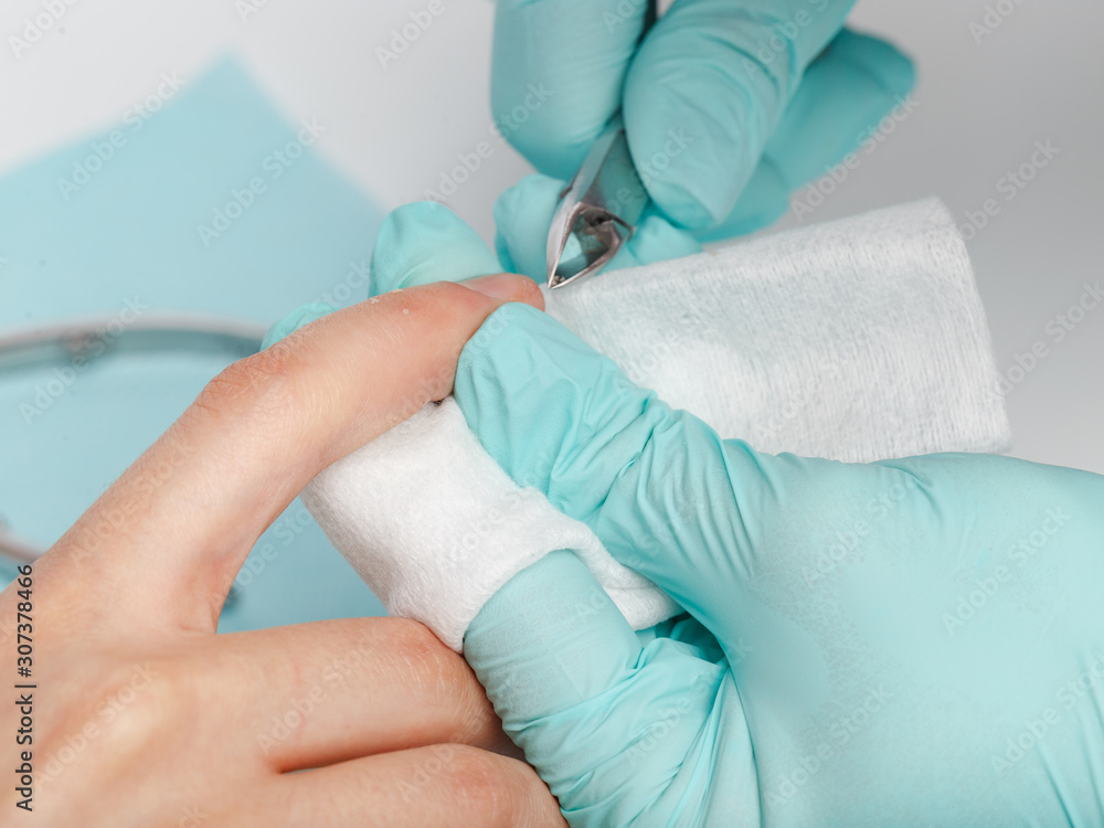 process manicure on fingernails from a professional manicurist in a salon or spa, close up top view process manicure on fingernails from a professional manicurist in a salon or spa, close up top view
