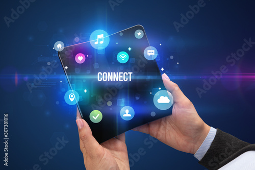 Businessman holding a foldable smartphone with CONNECT inscription, social media concept