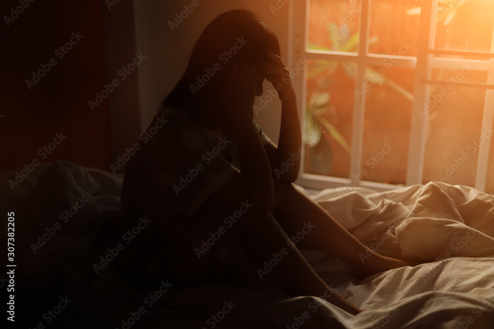 Fototapeta premium The woman sitting on the bed in the bedroom, stress