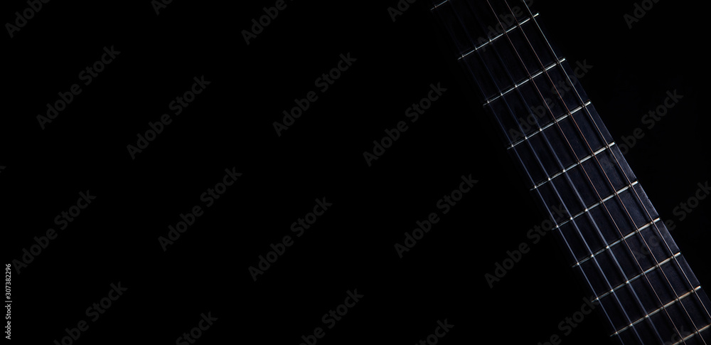 Classical guitar fretboard with strings on black background - obrazy, fototapety, plakaty 