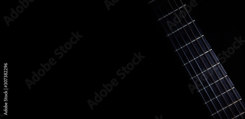 Classical guitar fretboard with strings on black background