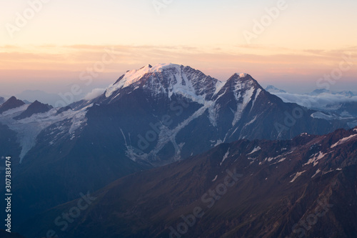 beautiful sunrise in the mountains. Golden hour photography  the rising sun behind the mountains. Yellow and pink color. Mount Elbrus. Russia. The Caucasus. Panorama of mountains at sunrise.