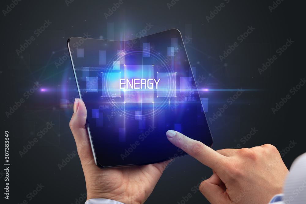 Obraz premium Businessman holding a foldable smartphone with ENERGY inscription, new technology concept