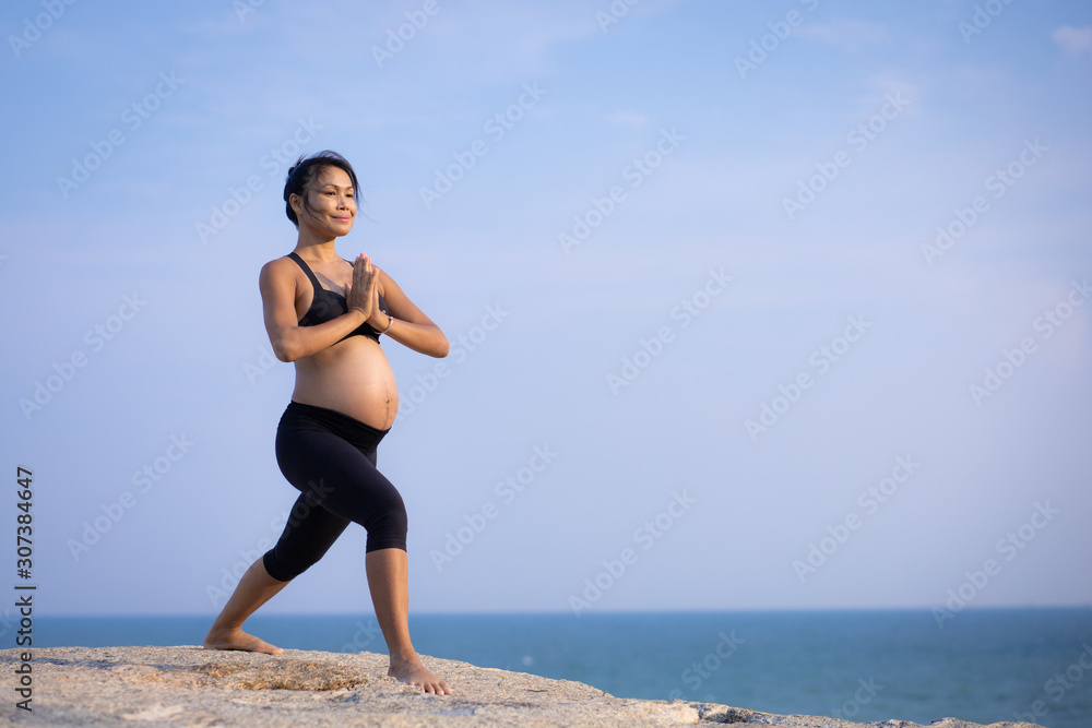 pregnant woman yoga pose on the beach sunset pregnant woman yoga pose on the beach sunset