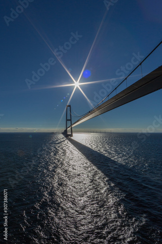 Oresund bridge with blue sky, blue sea, sun and flares